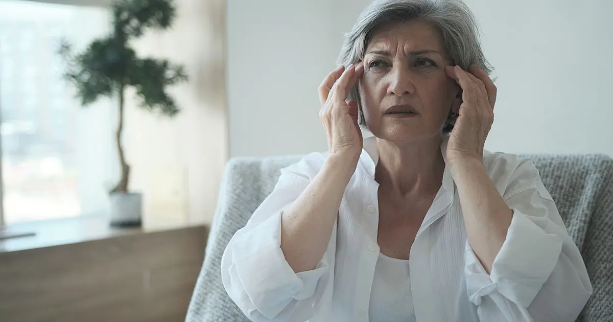 Idosa com expressão preocupada representando dificuldades de memória e impacto da solidão.