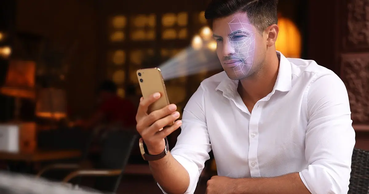 Homem desbloqueando notebook com biometria facial usando reconhecimento do rosto.