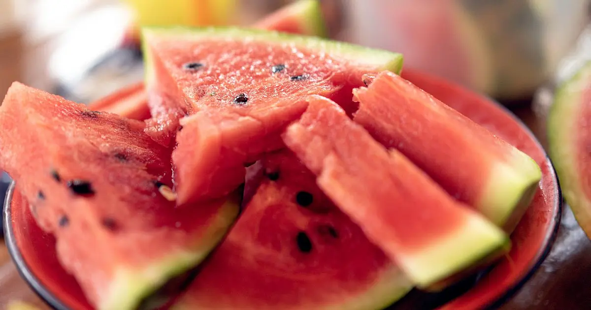 Fatias de melancia com sementes em destaque durante consumo da fruta