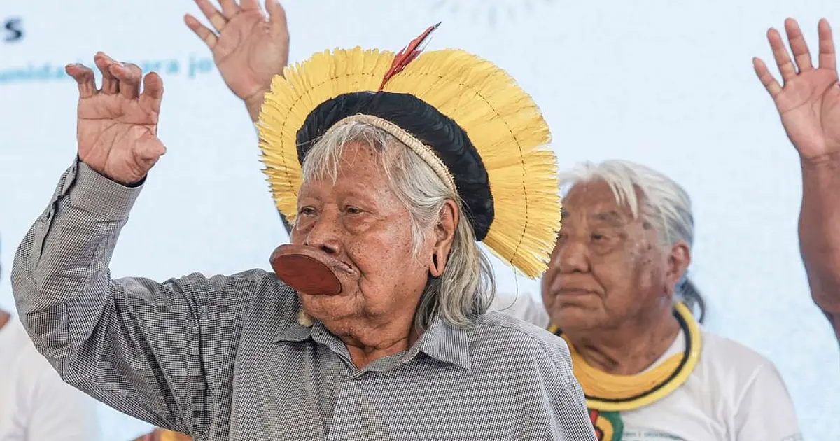 Cacique Raoni durante evento público usando cocar tradicional indígena.