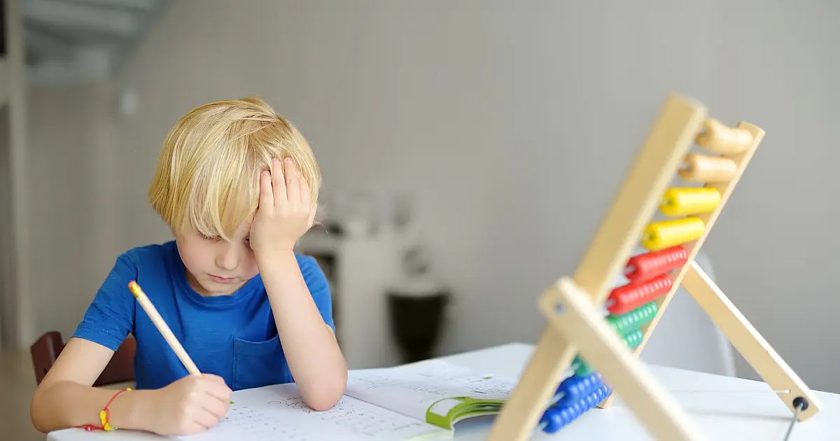 Criança realizando atividades escolares em casa durante acompanhamento educacional.
