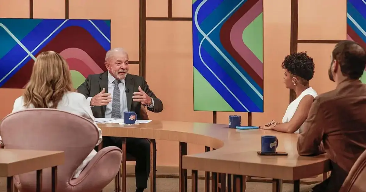 Fotografia em plano médio do presidente Luiz Inácio Lula da Silva falando ao microfone durante entrevista coletiva oficial.