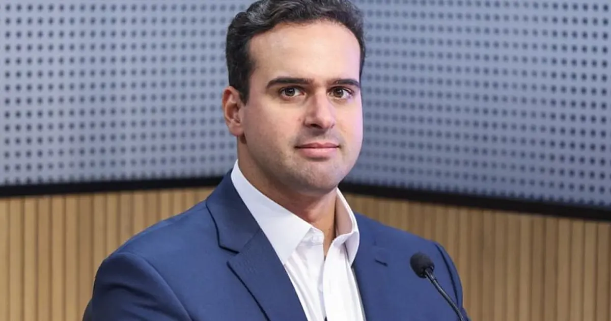 Fotografia oficial do governador Lucas Ribeiro sorrindo durante uma entrevista coletiva