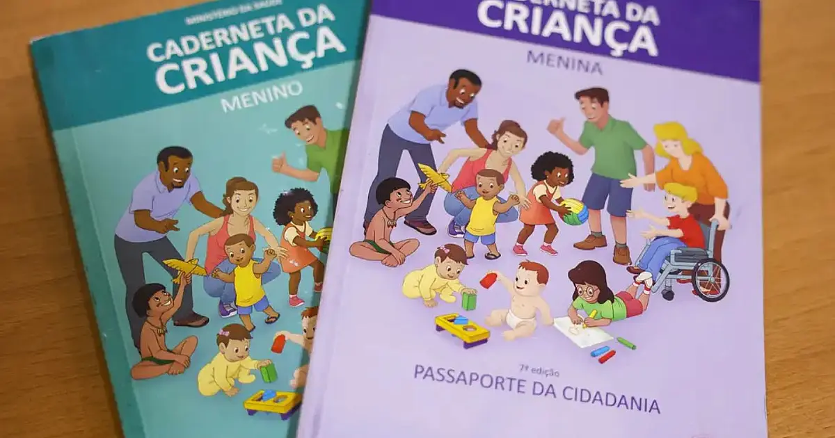 Mão de um profissional de saúde segurando um livreto colorido com ilustrações infantis em uma sala de atendimento médico