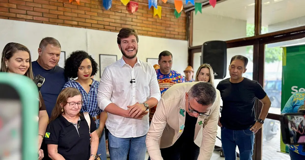 Gestores e integrantes de grupos culturais reunidos assinando o documento de convênio financeiro em uma sala institucional