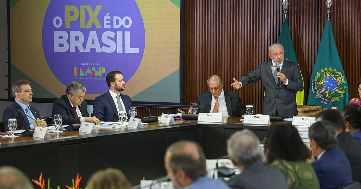 Fotografia em plano médio do presidente Lula falando ao microfone durante uma mesa redonda corporativa