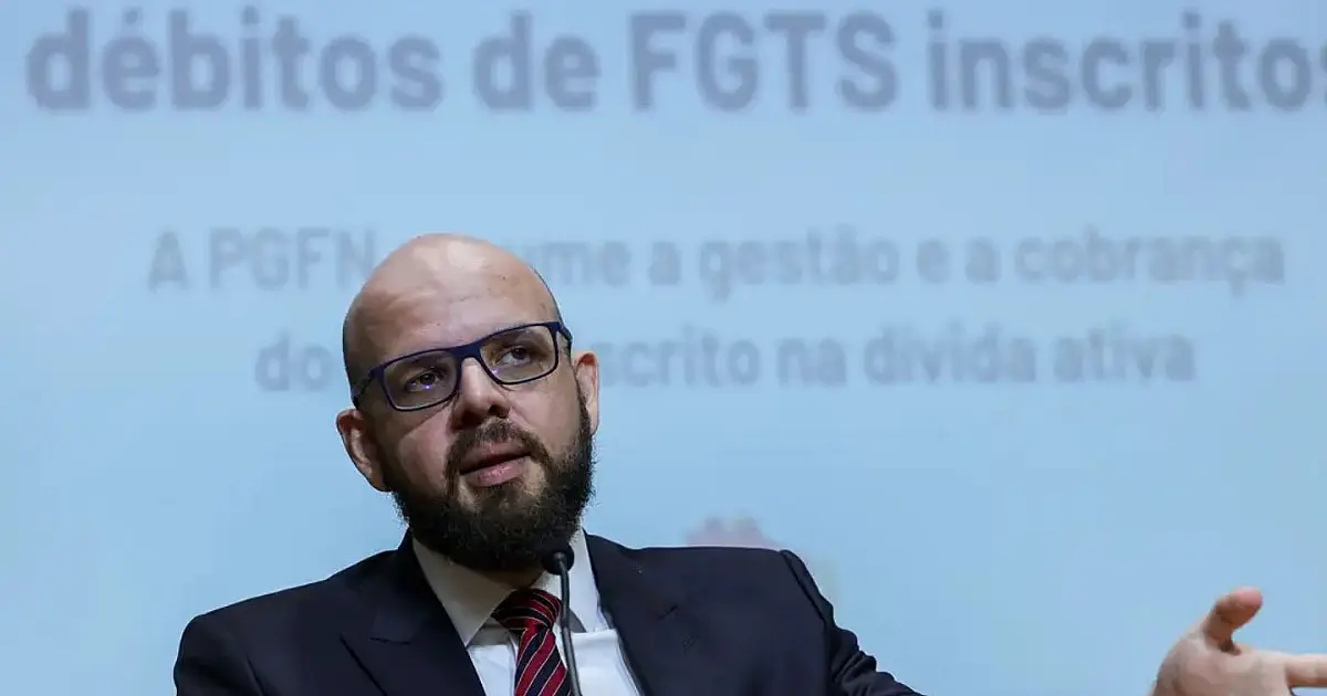 Fachada externa em ângulo contra-plongé do edifício-sede da Procuradoria-Geral da Fazenda Nacional, exibindo os vidros espelhados e a identificação institucional do órgão público.