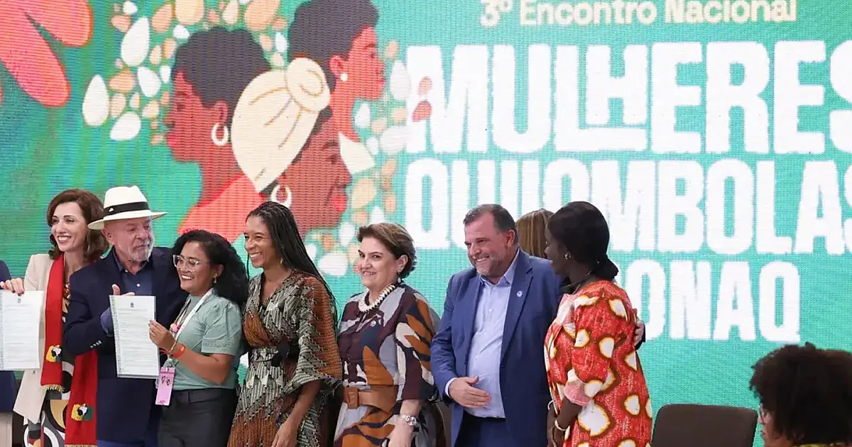 O presidente Lula ao lado de lideranças femininas negras que exibem com orgulho os certificados oficiais de titulação de terras emitidos pelo Incra.